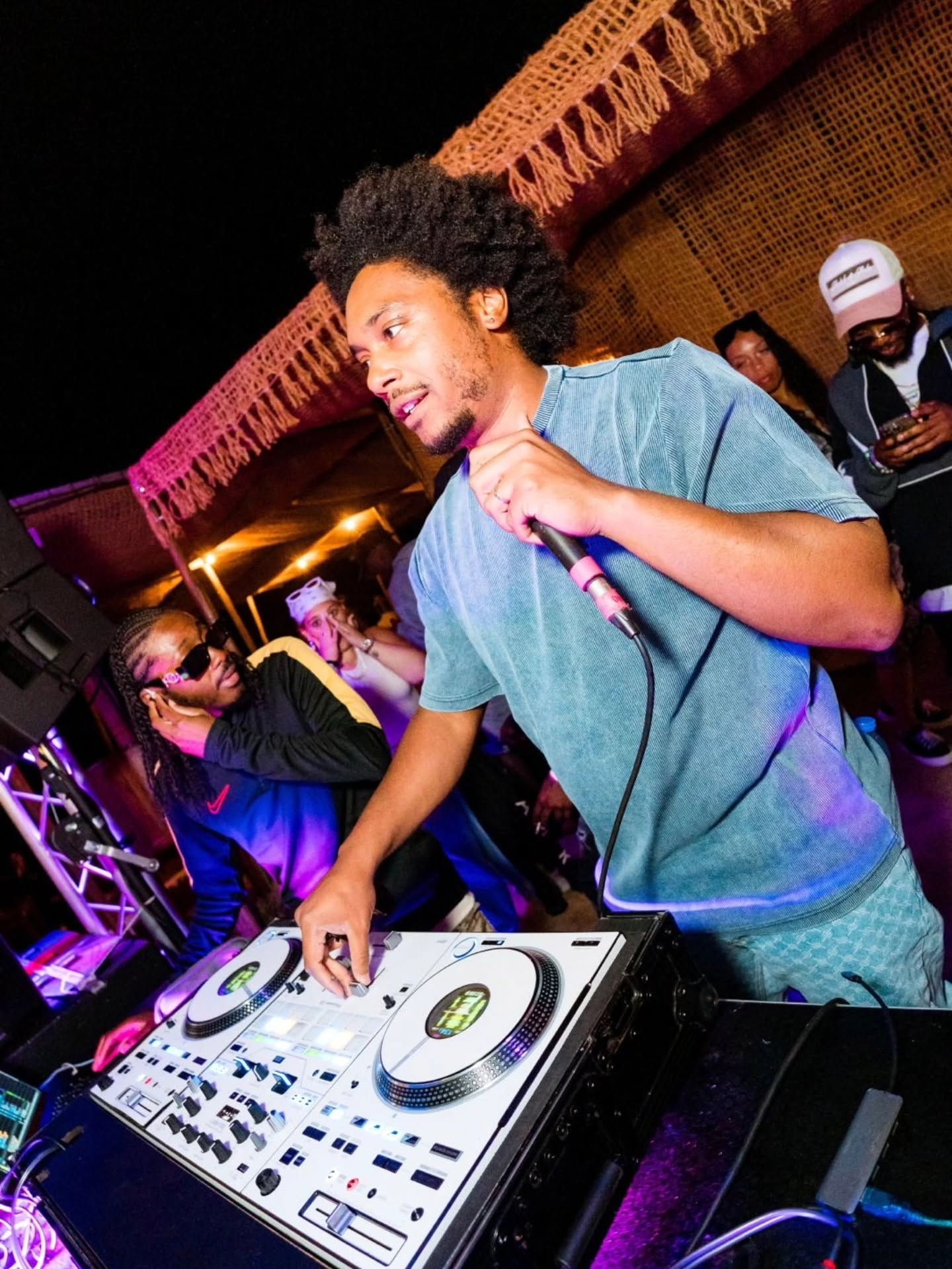 DJ Wally au micro derrière ses platines, en pleine soirée Sun Bailante