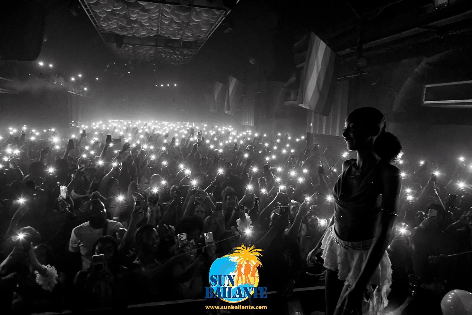 Silhouette sur scène devant une marée de téléphones allumés, soirée Sun Bailante